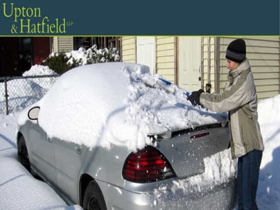 Woman brushing snow off car