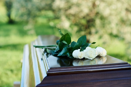 Casket with white roses on top