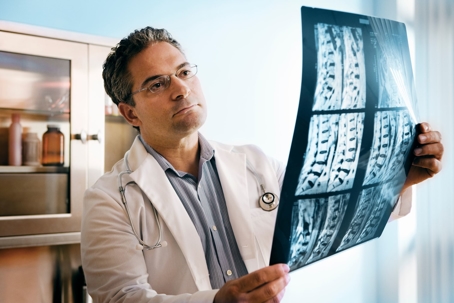 doctor looking at spinal chord xrays