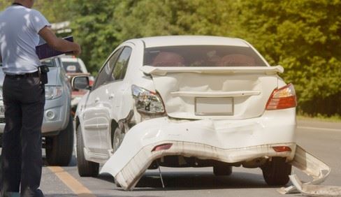 man examining car after rear end accident