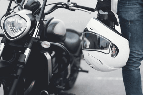 man with motorcycle helmet standing next to bike